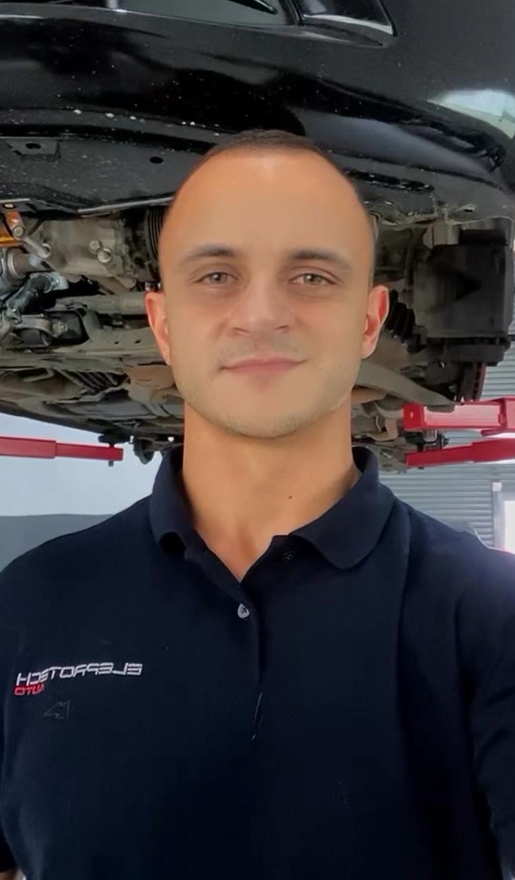 Especialista da Eleprotech Auto ao lado de um ve&iacute;culo Mitsubishi